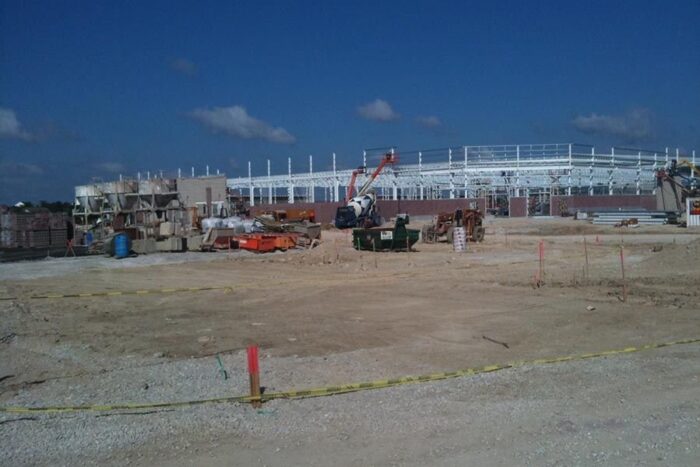 large metal building construction site with brick cladding the lower part of the exterior walls